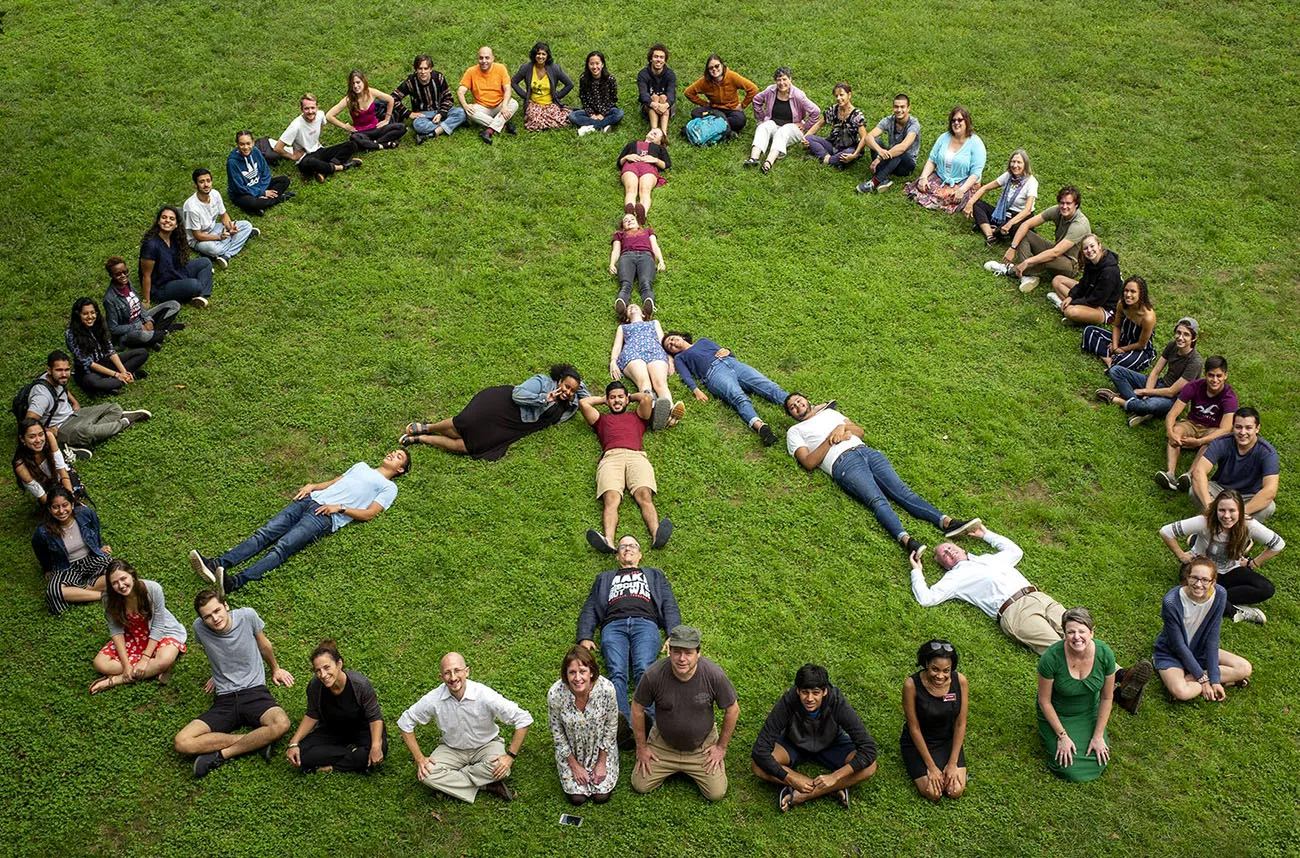 students and faculty forming a peace sign