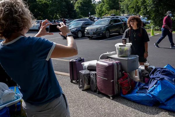 A student poses with their bags on move in day