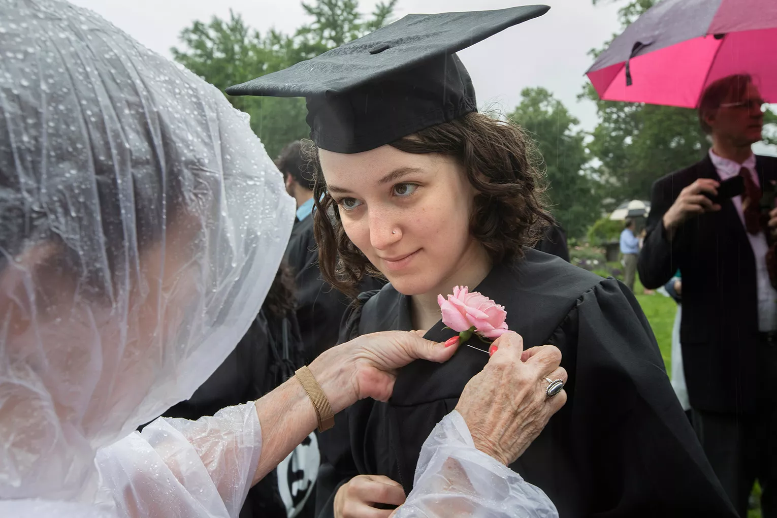 Student receiving rose on lapel at commencement