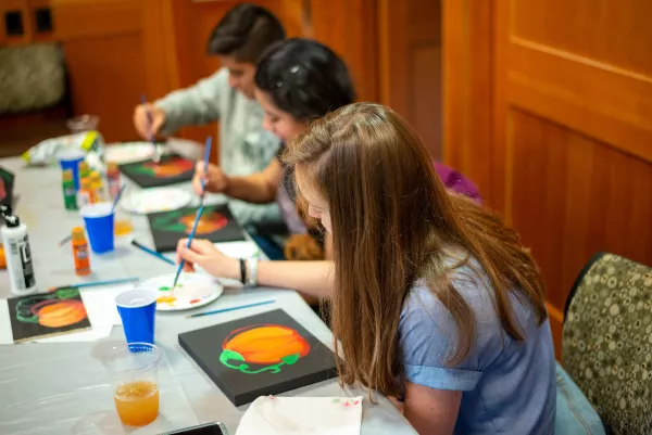 Students painting pumpkins