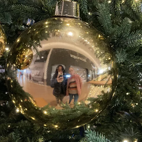student and her host family sister reflected in a christmas ornament