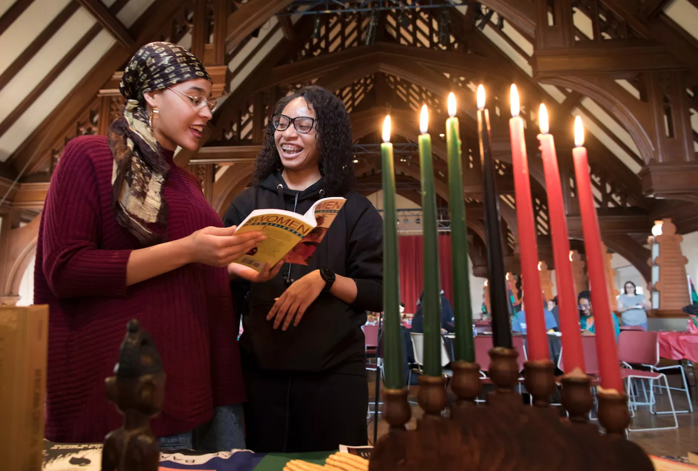 Two women lighting Kwanzaa candles